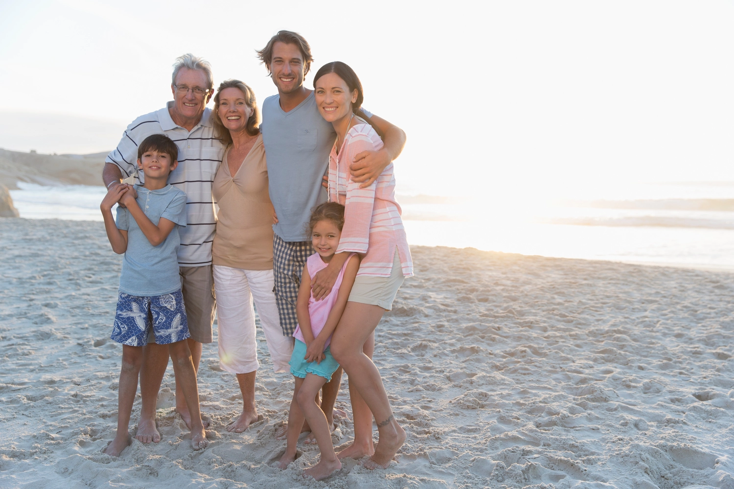 PCR-Test – Privatkunden – Porträt einer glücklichen Mehrgenerationenfamilie am sonnigen Strand